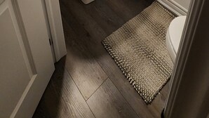 Un baño con lavamanos blanco, un espejo y una lámpara sobre el espejo.