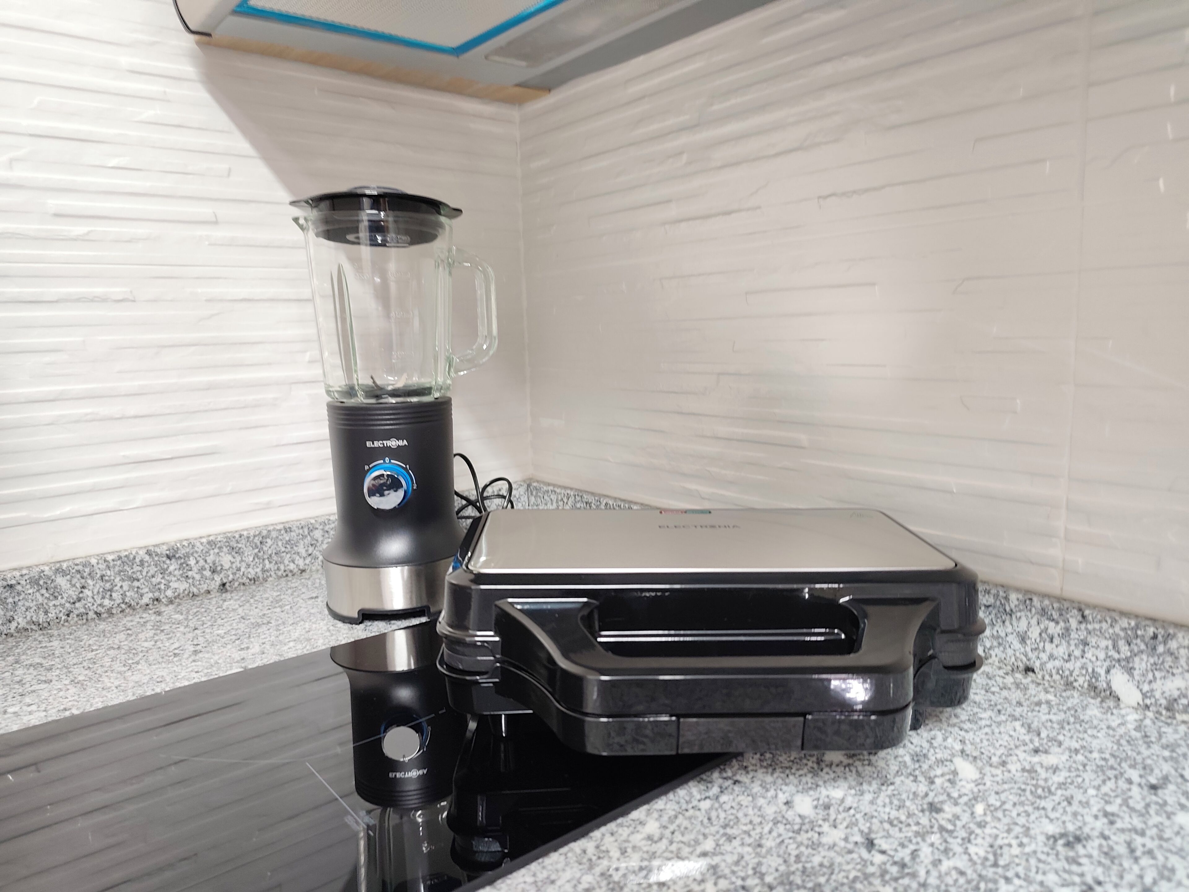 Una cocina con una licuadora y un tostador sobre una encimera de granito.