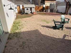 A backyard with a gravel area, a wooden deck, and a small shed. - Pecan Grove | Spacious South Abilene Stay (Abilene)