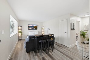 A modern kitchen with a bar area, a dining table, and a sofa. - UO•Downtown(.5 mile)•West University•GuestFavorite (Eugene)