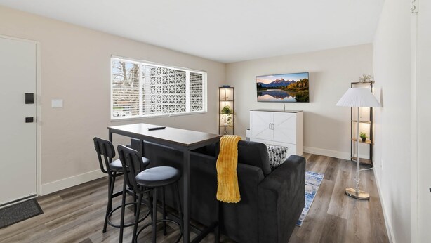 A modern living room with a dining area, a sofa, a TV, and a lamp. - UO•Downtown(.5 mile)•West University•GuestFavorite (Eugene)