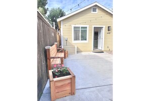 A house with a wooden fence, a concrete patio, and a wooden planter box with pink flowers. - Beautiful 1 BR 1  Bath craftsman style house in family friendly Normal Heights (San Diego)