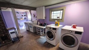 A laundry room with a washing machine, dryer, and a small window. - East Vancouver Bachelor Basement Suite. Pet Friendly - No Fee. Next to Transit. (Vancouver)