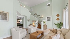 Una sala de estar amplia con escalera, comedor y cocina.