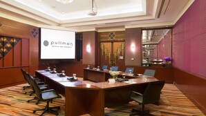A conference room with a long table, chairs, a projector screen displaying 'Pullman Hotels and Resorts', and a modern chandelier. - The Heritage Grand Khon Kaen Hotel and Convention (Khon Kaen)