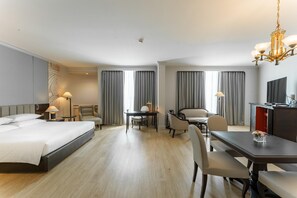 A hotel room with a large bed, a desk, two chairs, a TV, and a chandelier. - The Heritage Grand Khon Kaen Hotel and Convention (Khon Kaen)