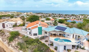 Ein modernes Haus mit Swimmingpool, Solaranlage und Meerblick.