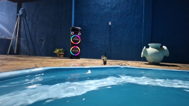 A swimming pool with a blue wall and a large decorative vase.