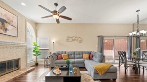 Ein modernes Wohnzimmer mit einer Eckcouch, einem Couchtisch und einem Essbereich mit einem Glastisch und Stühlen.