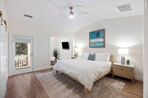 A bedroom with a bed, bedside tables, a ceiling fan, a TV, and a painting on the wall. - UPDATED Seabook Townhome, Elevator, Golf Cart, Club Access at Fairway One Villas, SUMMER OPENINGS! (Seabrook Island)