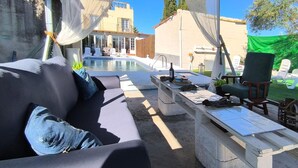 An outdoor seating area with a pool, a sofa, a table, and a chair. - Cozy home in Guillena (Guillena)