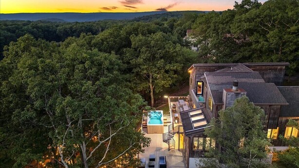 Una casa con idromassaggio, terrazza e vista sulla foresta.