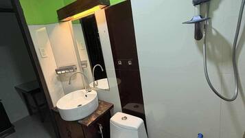 A bathroom with a toilet, sink, and shower.