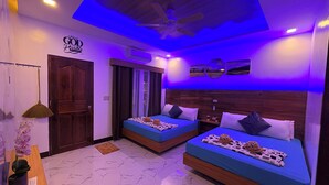 Un dormitorio con dos camas, ventilador de techo y aire acondicionado de pared.