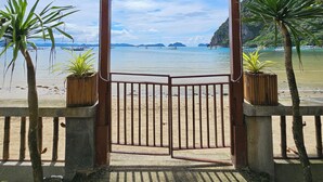 Entrada techada a una playa con vista al mar y a islas distantes.