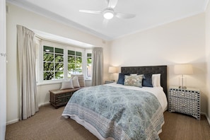 A bedroom with a large bed, two bedside tables with lamps, a ceiling fan, and a window with curtains. - Toorak Escape—Serene Stay near Burnside Village (Toorak Gardens)