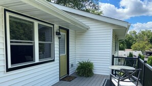 A house with a covered porch, a door, and a small garden area.