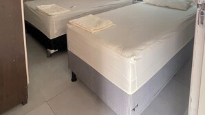 Quarto com duas camas, janela com vista e ar condicionado.