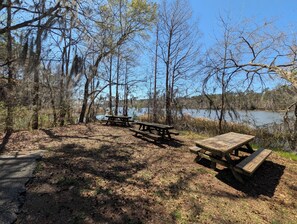 A picnic area with benches and a path leading to a lake surrounded by trees. - Spacious 5-bedroom Master's Retreat, North Augusta. 8.7 mi. to Augusta National (North Augusta)