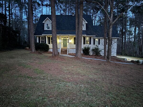 A two-story house with a front porch, surrounded by trees. - Spacious 5-bedroom Master's Retreat, North Augusta. 8.7 mi. to Augusta National (North Augusta)