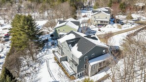 Vecindario residencial con casas rodeadas de nieve y árboles.
