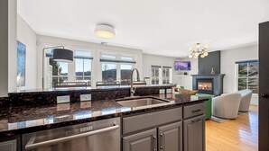 Una cocina moderna con encimeras de granito, electrodomésticos de acero inoxidable y un amplio ventanal con vistas a un paisaje pintoresco.