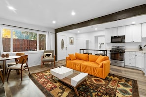 Una sala de estar moderna con un sofá, una mesa de centro y sillas.