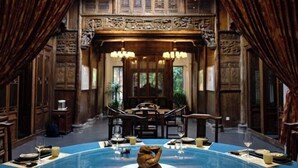 A traditional room with a dining table, chairs, and a blue carpet. - Yayunju Inn (Shanghai)