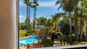 A pool with palm trees and a clear sky. - Villa Gialla Private Padel Court (Aci Sant'Antonio)