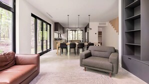 Uma sala de estar moderna com sofá, poltrona e estante.