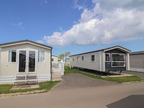 A row of mobile homes with a paved walkway between them. - Ty Mawr Holiday Park - Holiday Accommodation 22393 (Abergele)