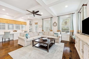 A living room with a sectional sofa, a coffee table, a TV, and a fireplace. - Community Pool, Sleeps 10, Sunrise & Serenity, Bikes (Seagrove Beach)