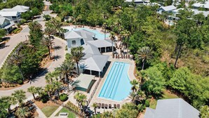 Vista aérea de um resort com piscina, vários edifícios e paisagismo exuberante.