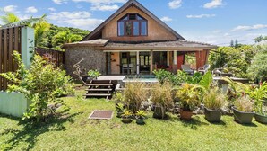 Ein Haus mit einer Steinfassade, einem dreieckigen Dach und einer Veranda mit Stufen zum Eingang.