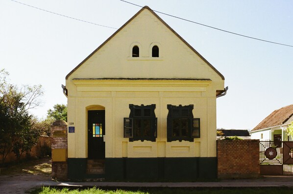 A building with a gabled roof, a door, and two windows with shutters. - Authentic Slavonian home with pool, barbecue and orchard (Lug)