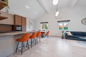 Une cuisine moderne dotée d’un coin bar, d’un espace repas et d’un salon avec un canapé et une table basse.
