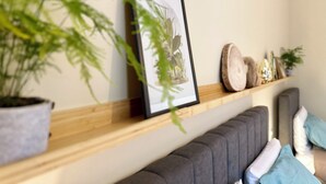 A room with a wooden shelf holding a framed picture, a potted plant, and decorative items. - Elegant and Private, close to the city center. Gran Dimora dei Sensi e Charme. (Bergamo)