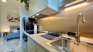 A modern kitchen with a stainless steel sink, a built-in stove, and a countertop with a plant. - Elegant and Private, close to the city center. Gran Dimora dei Sensi e Charme. (Bergamo)