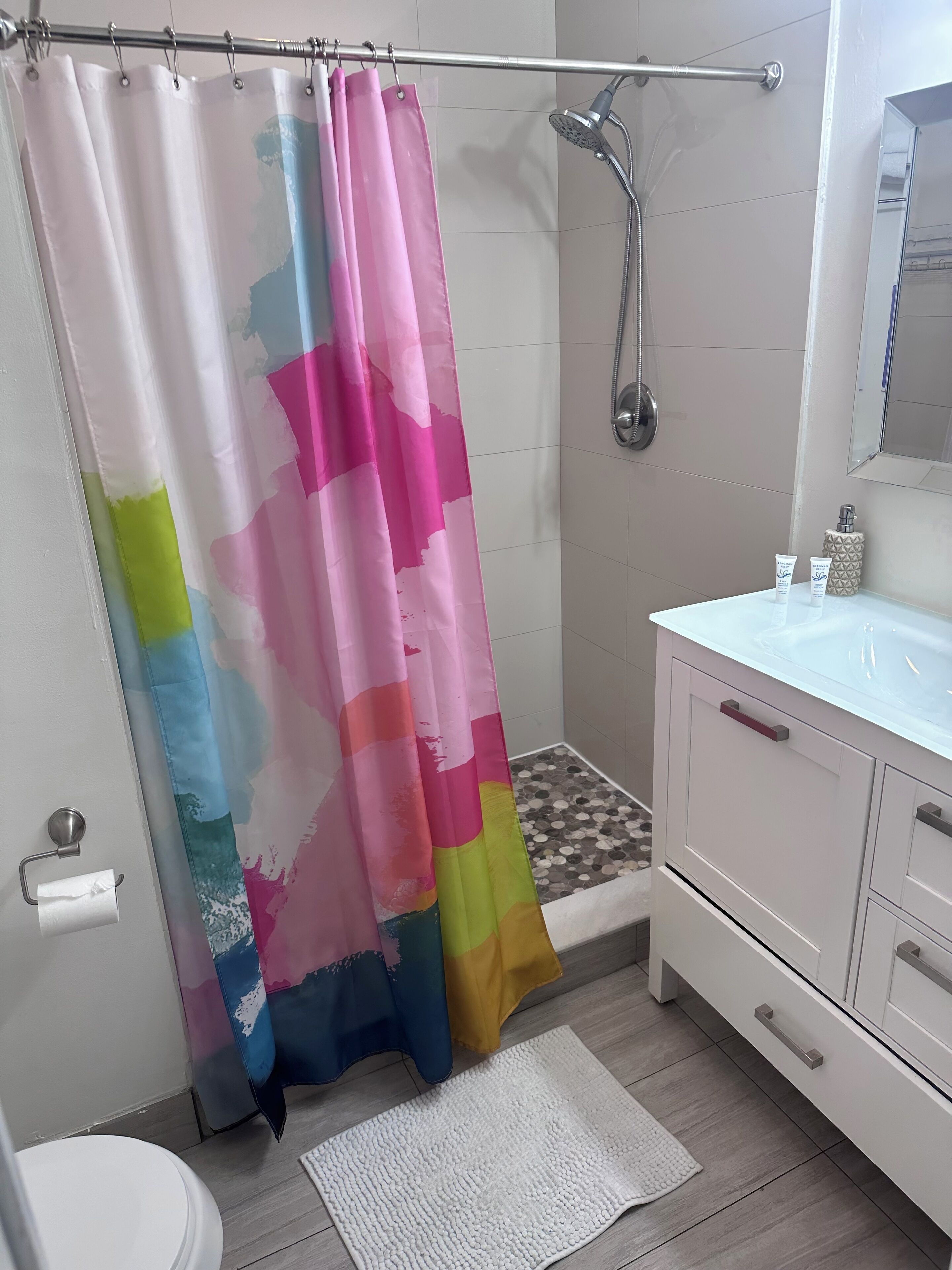 Une salle de bain avec douche, toilettes et lavabo.