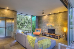 Una sala de estar moderna con un sofá, televisión y chimenea.
