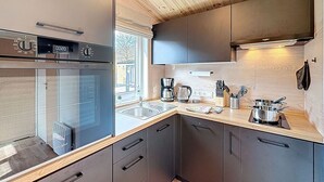 Eine moderne Küche mit Backofen, Kaffeemaschine und Spüle.