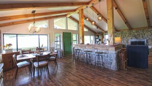 A spacious kitchen with a stone island, wooden beams, and a large window. - View 280- Amazing views of the Smoky Mountains (Bryson City)
