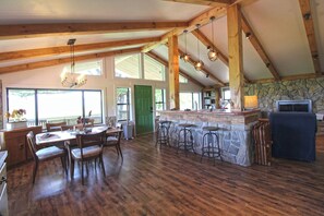 A spacious kitchen with a stone island, wooden beams, and a large window. - View 280- Amazing views of the Smoky Mountains (Bryson City)