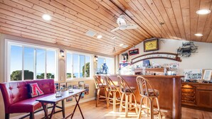 A restaurant with a wooden ceiling, a bar area, and a seating arrangement including a red sofa and wooden chairs. - Long Time No Sea Walk to Beach (Encinitas)