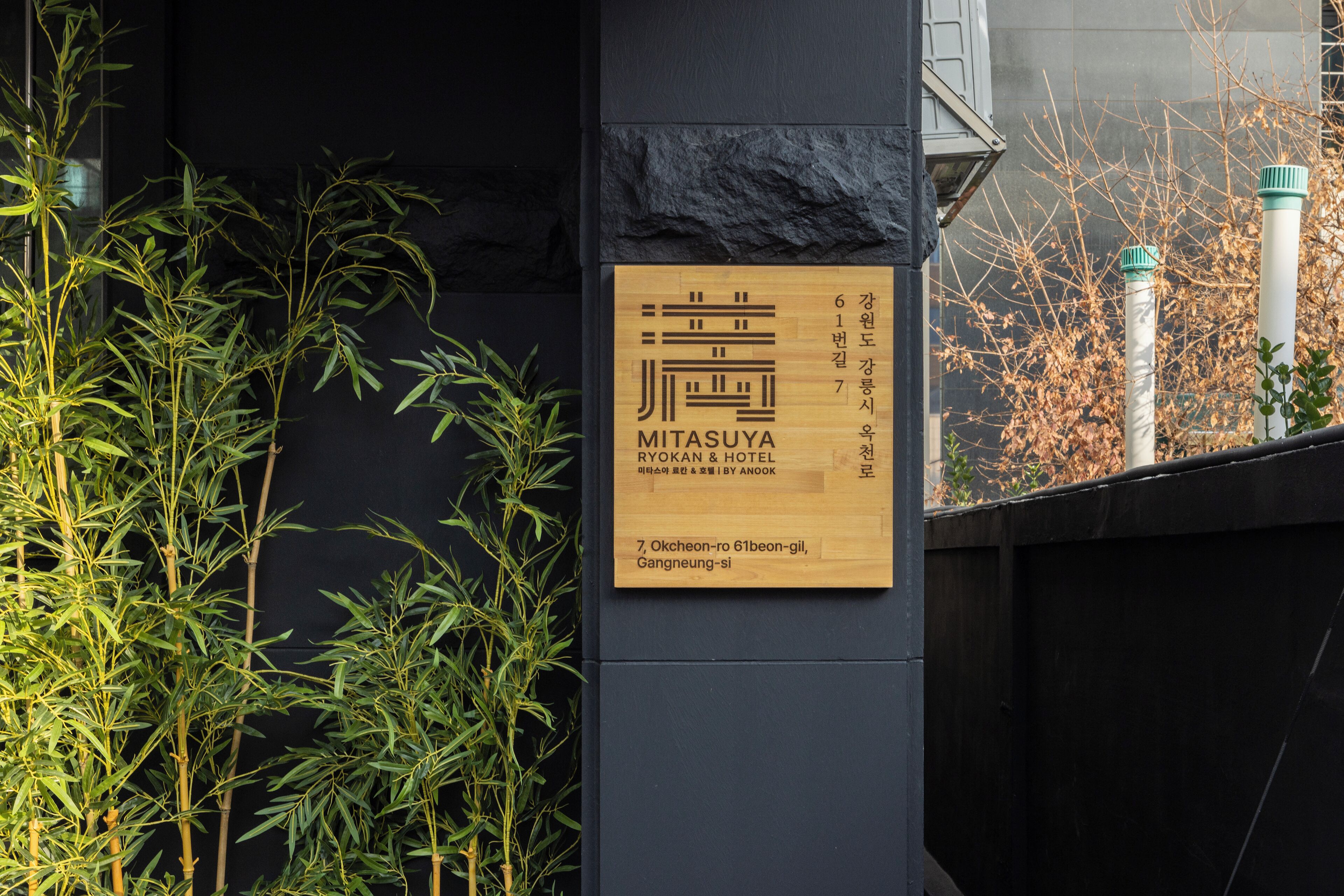 A hotel sign with a logo, name, and address.