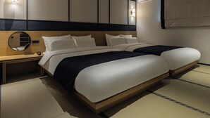 A hotel room with a bed, bedside tables, a mirror, and wall-mounted lighting. - mitasuyaryokanhotel by anook gangneung (Gangneung)