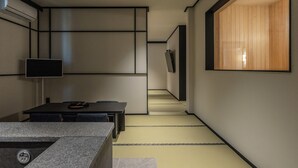 A modern interior with a flat-screen TV, a table, and a staircase. - mitasuyaryokanhotel by anook gangneung (Gangneung)