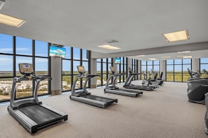 Ein Fitnessraum mit Laufbändern, Ergometer und einem Rudergerät.