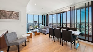A modern living room with a city view, a sofa, a dining table, and a chair. - Skyline Apartment in Fortitude Valley (Fortitude Valley)