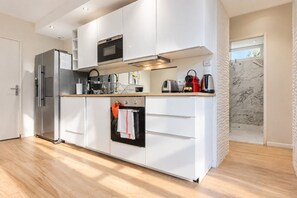 A modern kitchen with a built-in oven, microwave, and stainless steel refrigerator. - Beachfront Apartment with Terrace, Biarritz (Biarritz)